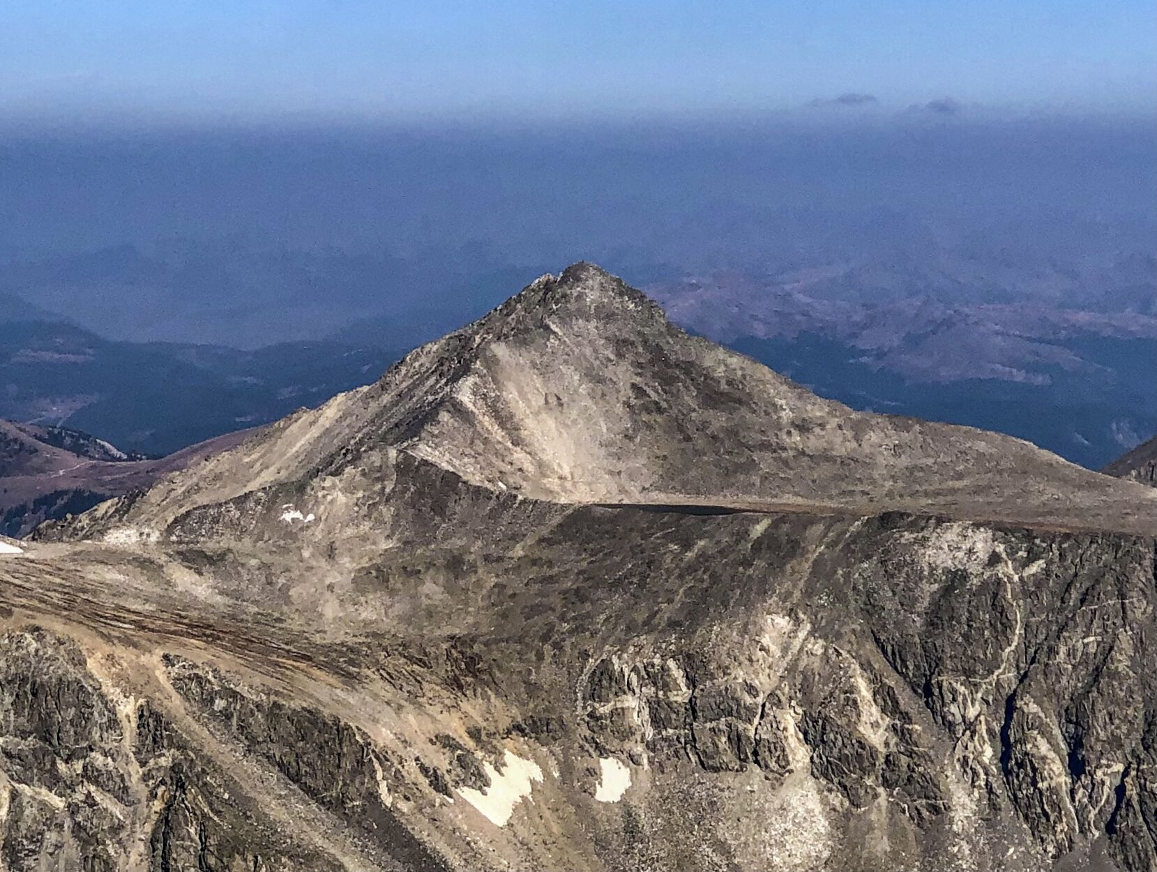 The lake and peak above the lake as seen from a nearby mountain. The lake is the thin line that's barely visible above the horizontal ridge mid-frame. Photo Credit: Spencer McKee.